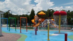 A water play area with slides and water jets. - Cozy 3 Bedroom Villa Near Disney (Kissimmee)