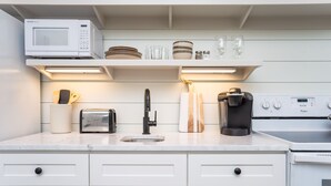 A modern kitchen with a microwave, toaster, coffee maker, and a sink. - The Harrington in downtown Beaufort  (Beaufort)