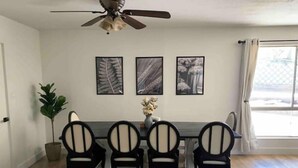A dining area with a table and four chairs, a ceiling fan, and three framed artworks on the wall. - Emerald Lake House- Boat Parking with a View of the Vermillion Cliffs (Page)