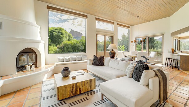 A modern living room with a fireplace, large windows, and a cozy seating area. - Red Rock Views: Uptown Sedona Home Near Trails! (Sedona)