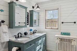 A bathroom with two sinks, a large mirror, and a window with a view of a wooden deck. - Monticello Vacation Rental w/ Private Boat Dock! (Monticello)