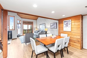 A dining area with a wooden table and white chairs, a sofa, and a fireplace. - KBM Resorts | Ridgepoint | Ski-in/Ski-out access, Common Hot Tub, Summer pool, Tennis, Parking, in Silver Lake Deer Valley! RGT-117 (Park City)