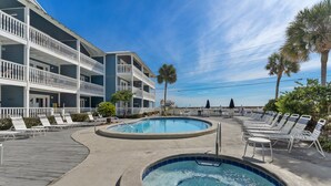 A hotel with a pool area, including a hot tub and lounge chairs. - Summer Breeze 1-Bed Condo! Gorgeous Views & Pool | Steps to Beach | Book Now! (Miramar Beach)
