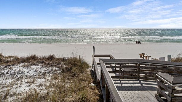 A beach with a wooden boardwalk leading to the water, a sandy area, and a clear sky. - Summer Breeze 1-Bed Condo! Gorgeous Views & Pool | Steps to Beach | Book Now! (Miramar Beach)