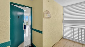 A hallway with a teal door, a number plaque, and a white radiator. - **THE LARK’S LANDING** Condo & Pool + Last Key White Glove Service... (Key West)