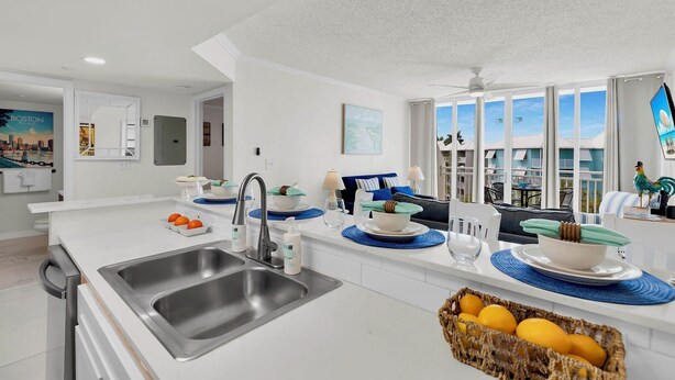 Una cucina moderna con una grande isola, lavello in acciaio inossidabile e vista all'esterno.
