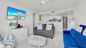 A modern living room with a gray sofa, a blue sofa, and a white coffee table.