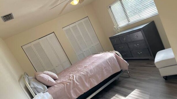 A bedroom with a bed, dresser, and closet. - Amazing 3 Bedroom Across From UF
 (Gainesville)