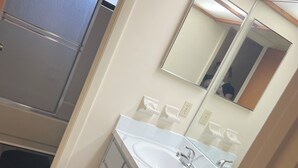 A bathroom with a white sink, mirror, and two cabinets. - Amazing 3 Bedroom Across From UF
 (Gainesville)