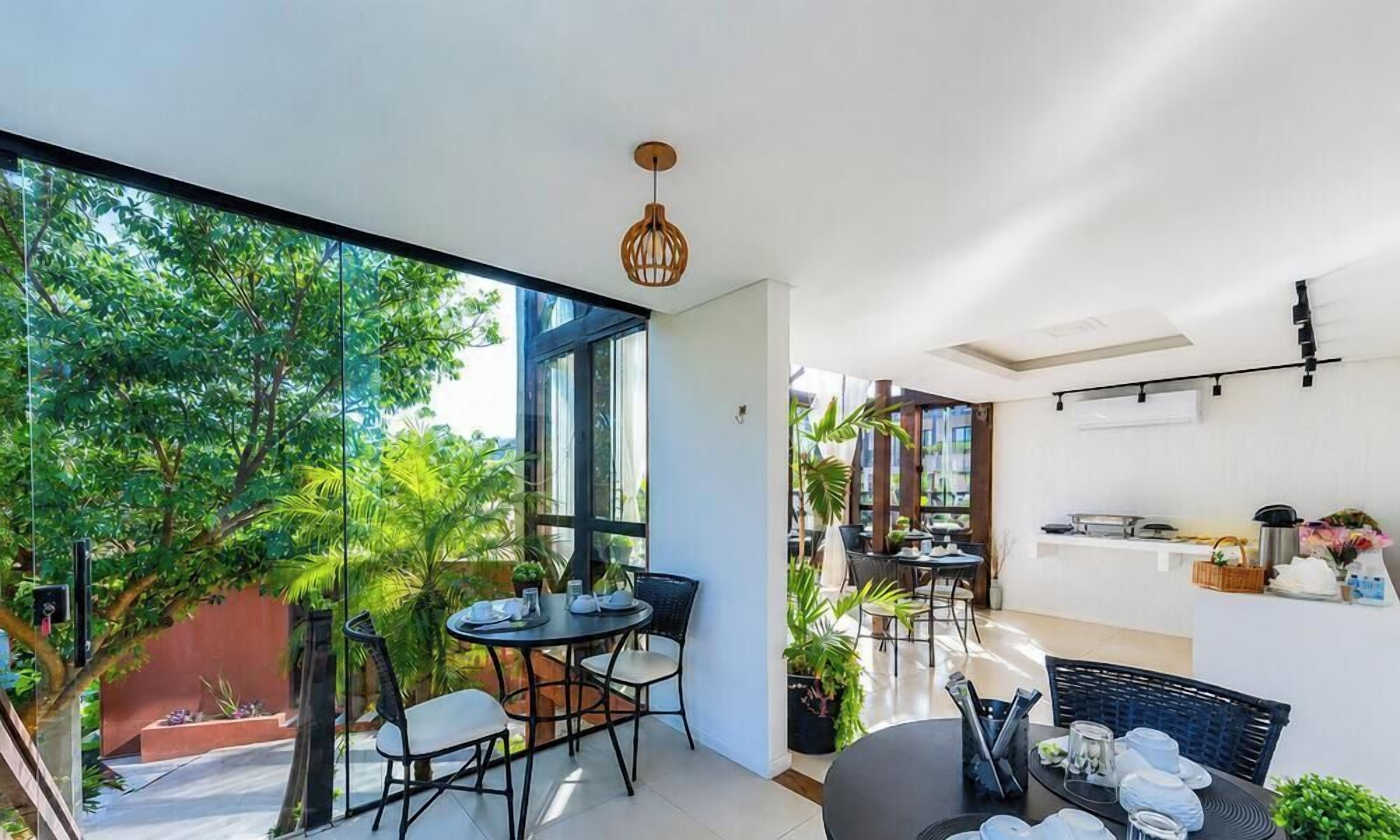 A modern interior with a dining area, large windows, and a kitchen.