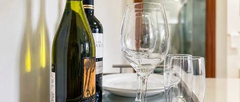 Una nevera minibar con botellas de vino y copas.