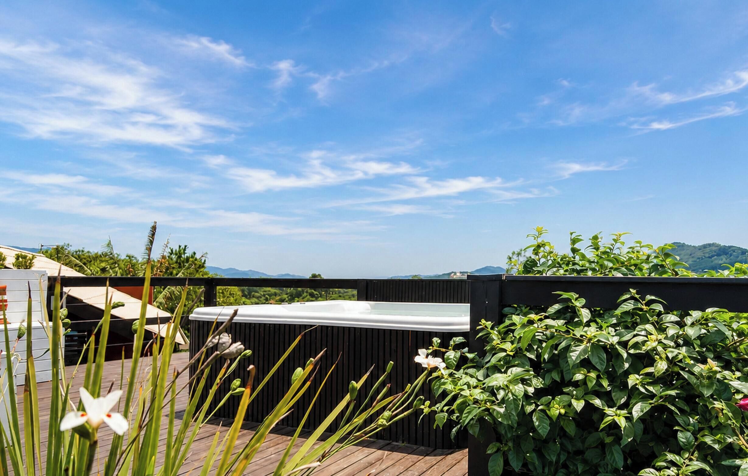 Terraza en la azotea con hidromasaje, piso de madera y abundante vegetación.