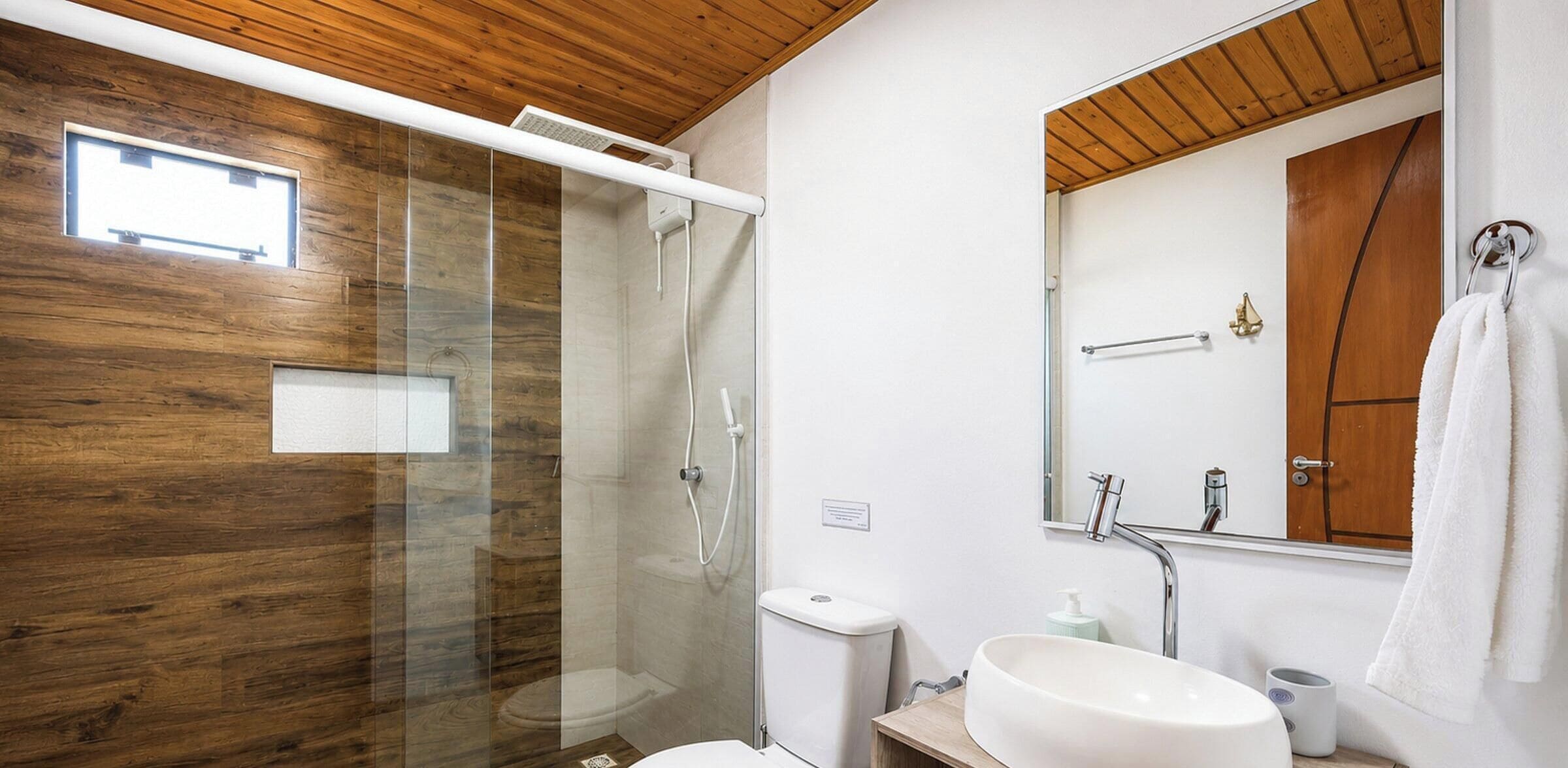 Un baño moderno con cabina de ducha de vidrio, inodoro, lavabo y espejo.