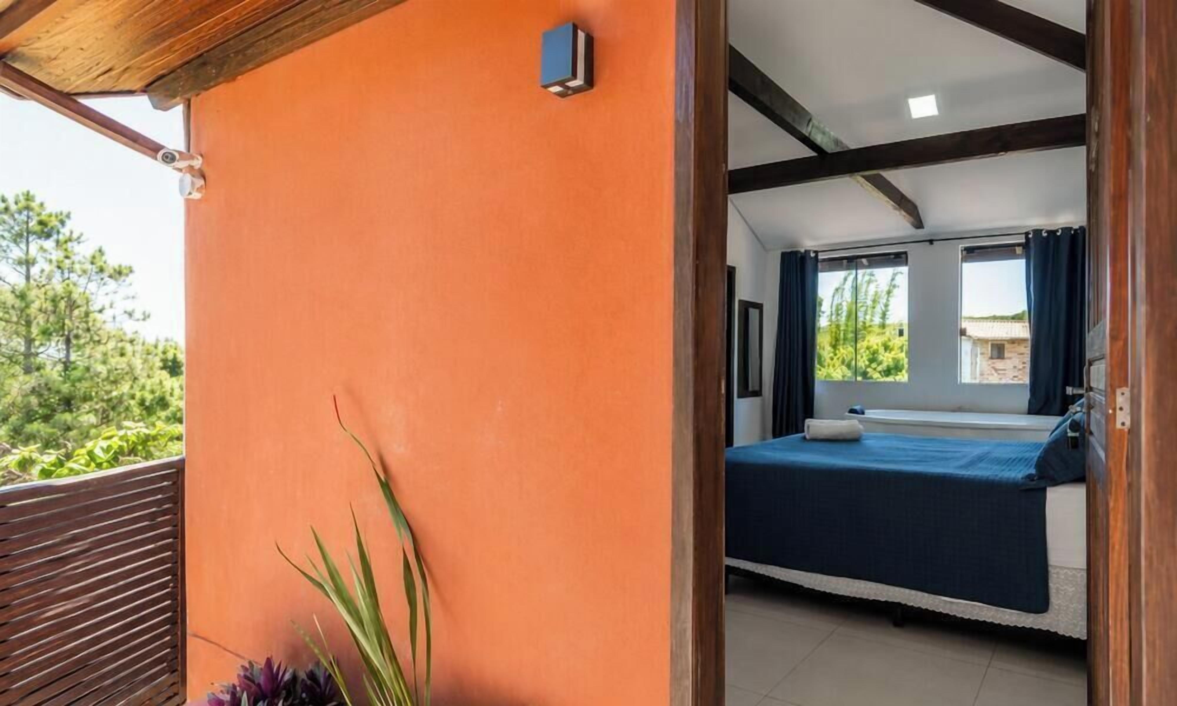 A bedroom with a bed, a window, and a view of greenery outside.