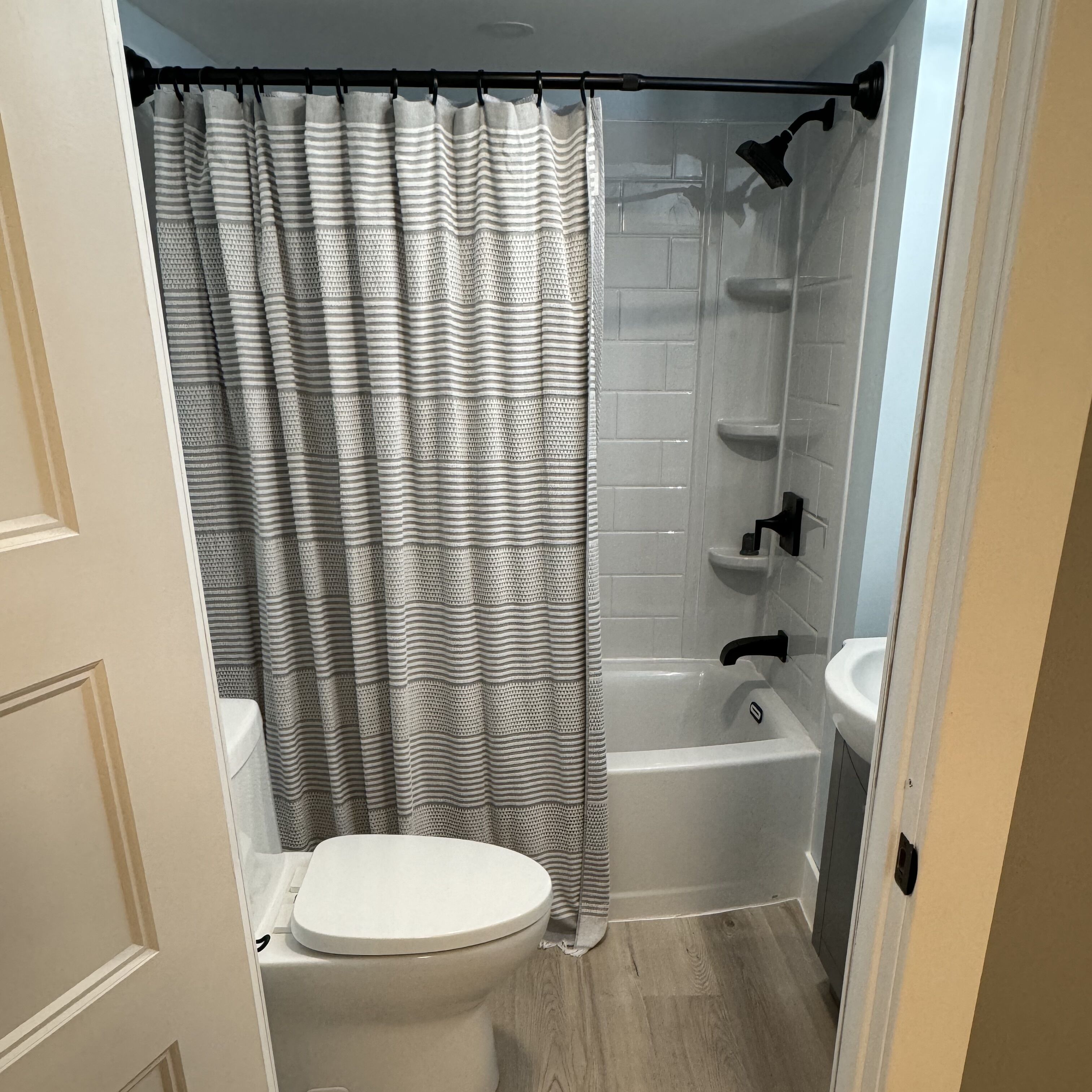 Un bagno con il water, una doccia e un lavandino.