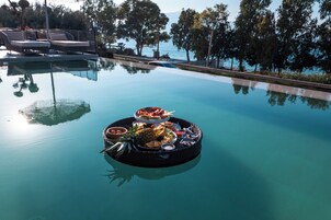 A poolside area with lounge chairs and a floating bar with various food and drink items.