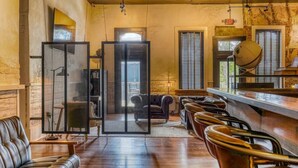 Un espace bar avec des fauteuils en cuir, un comptoir en bois et un globe décoratif.