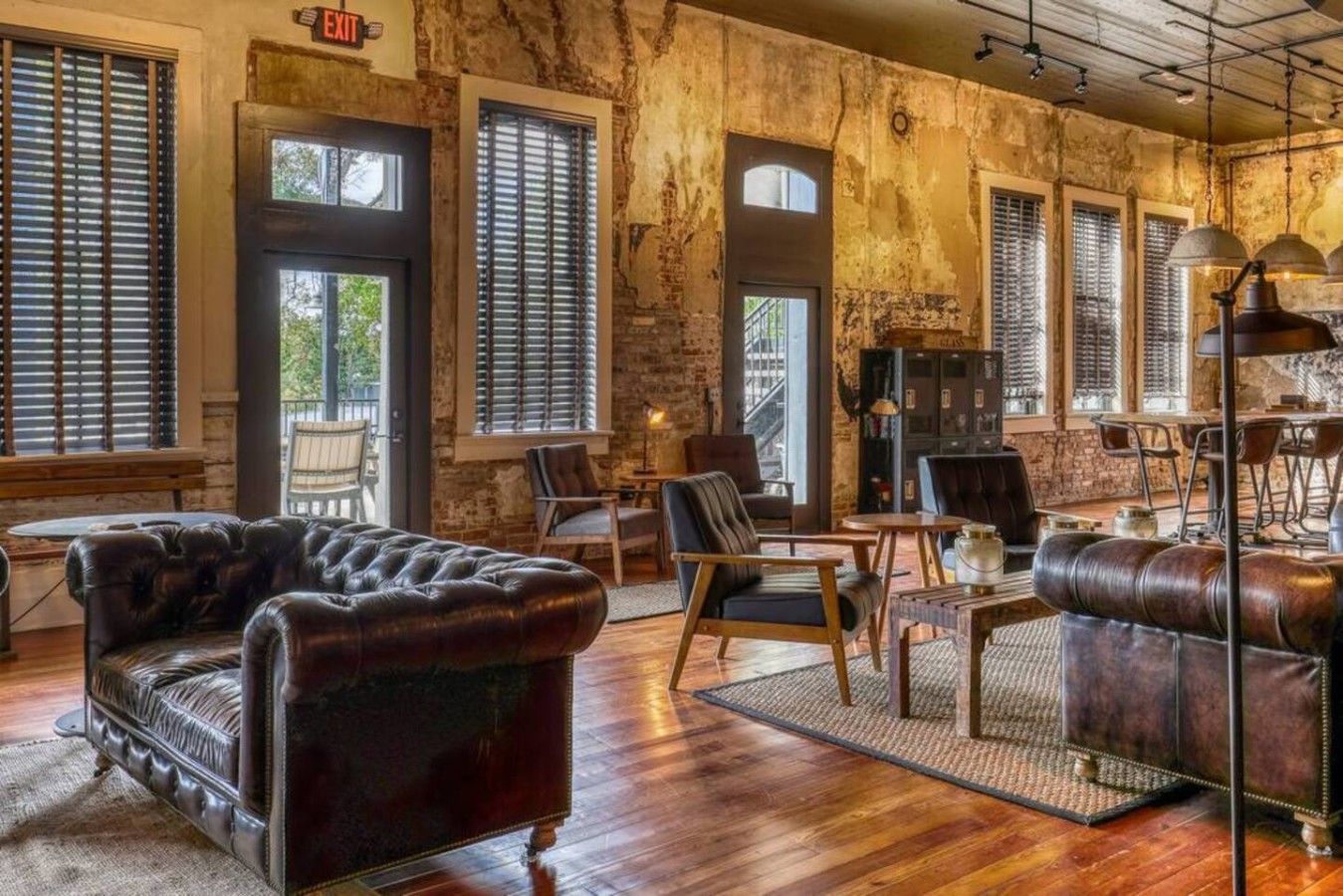 A rustic interior with leather sofas, wooden tables, and a fireplace.