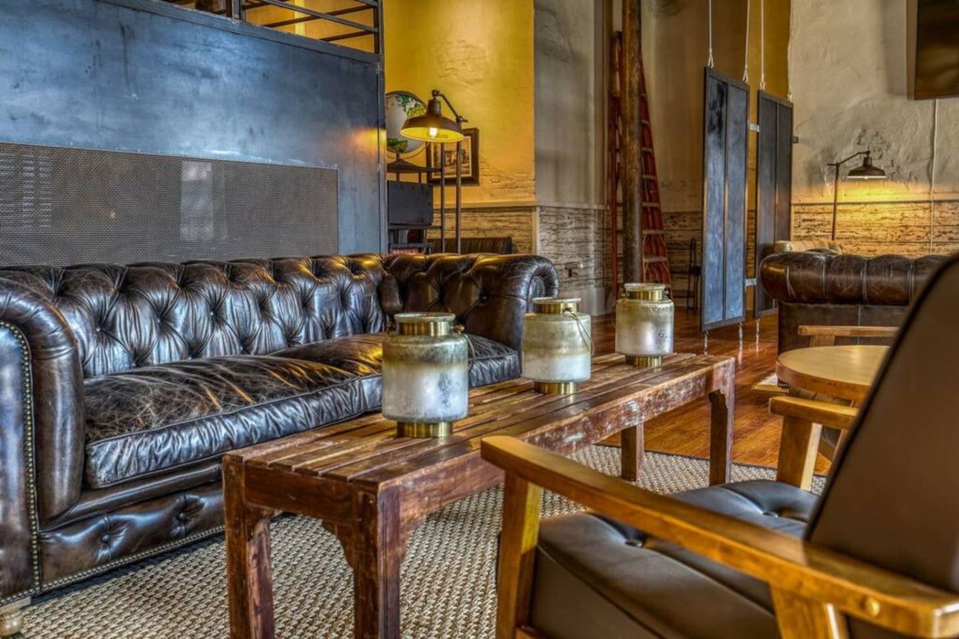 Une pièce avec un canapé en cuir, une table basse en bois et un fauteuil.