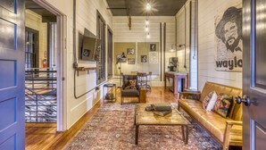 A spacious living room with a sofa, coffee table, and a patterned rug.