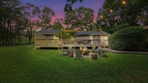 A two-story house with a deck, outdoor seating, and a fire pit. - Modern Rustic Private Ranch w/ Peloton! (Henryville)