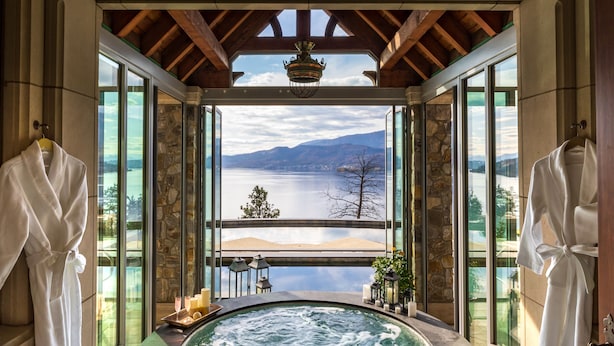 Wellnessbereich mit Whirlpool, Handtüchern und Blick auf See und Berge.