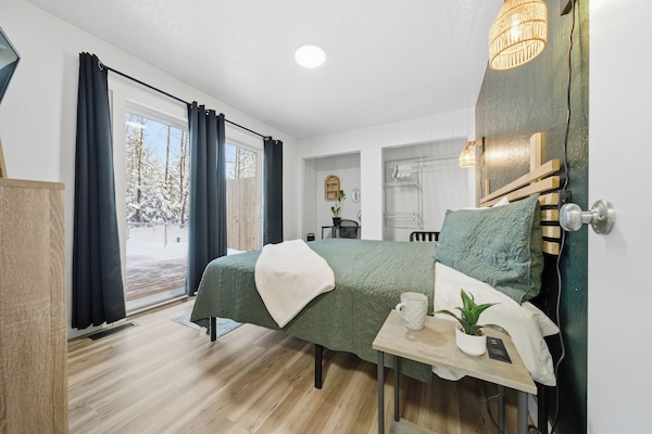 The king bedroom has a sliding door to the back deck, a tv, and a workspace.
