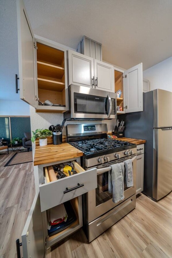 Cocina compacta con microondas, estufa y refrigerador integrados.