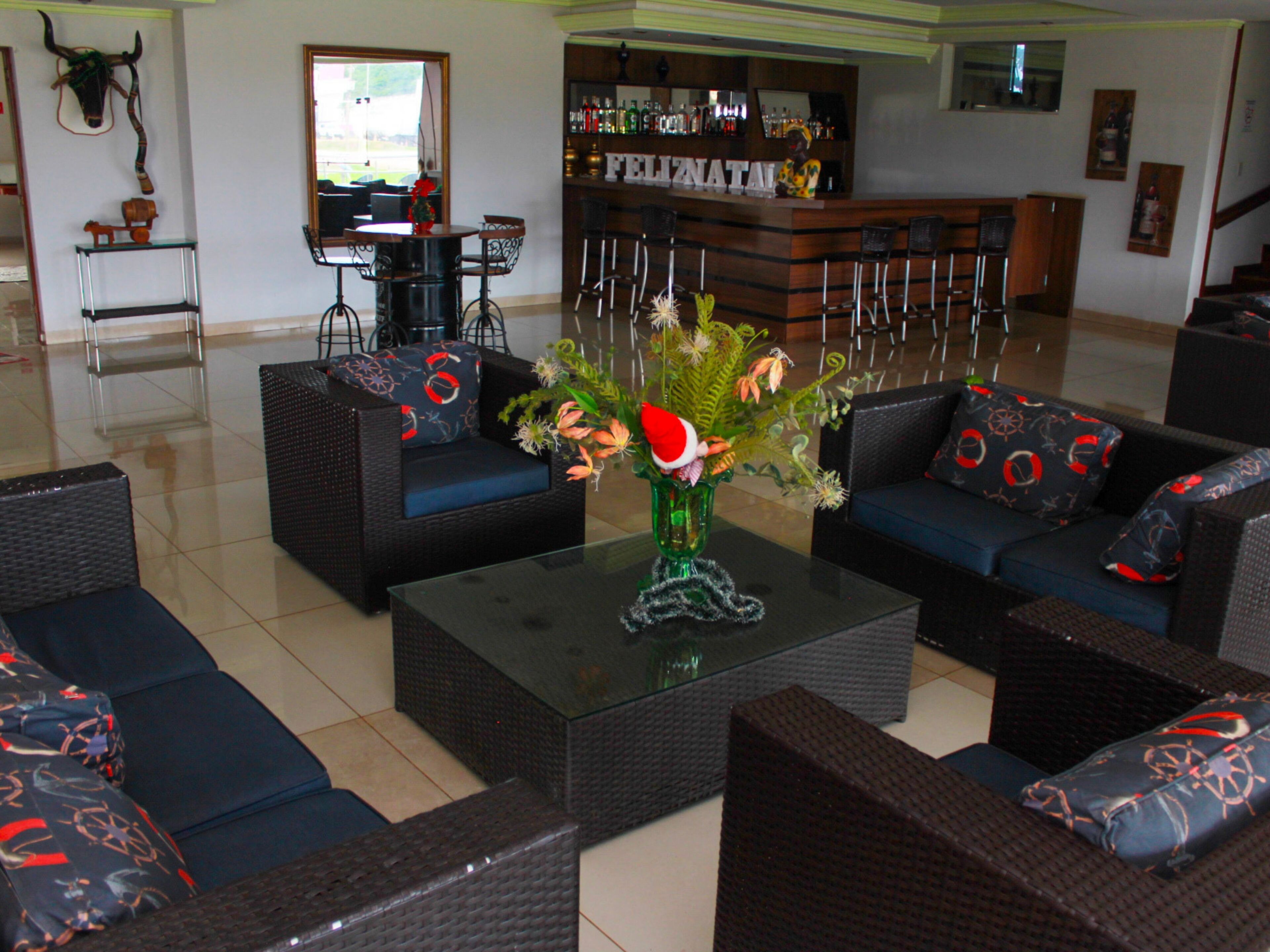 A bar area with a counter, bar stools, and a decorative wall.