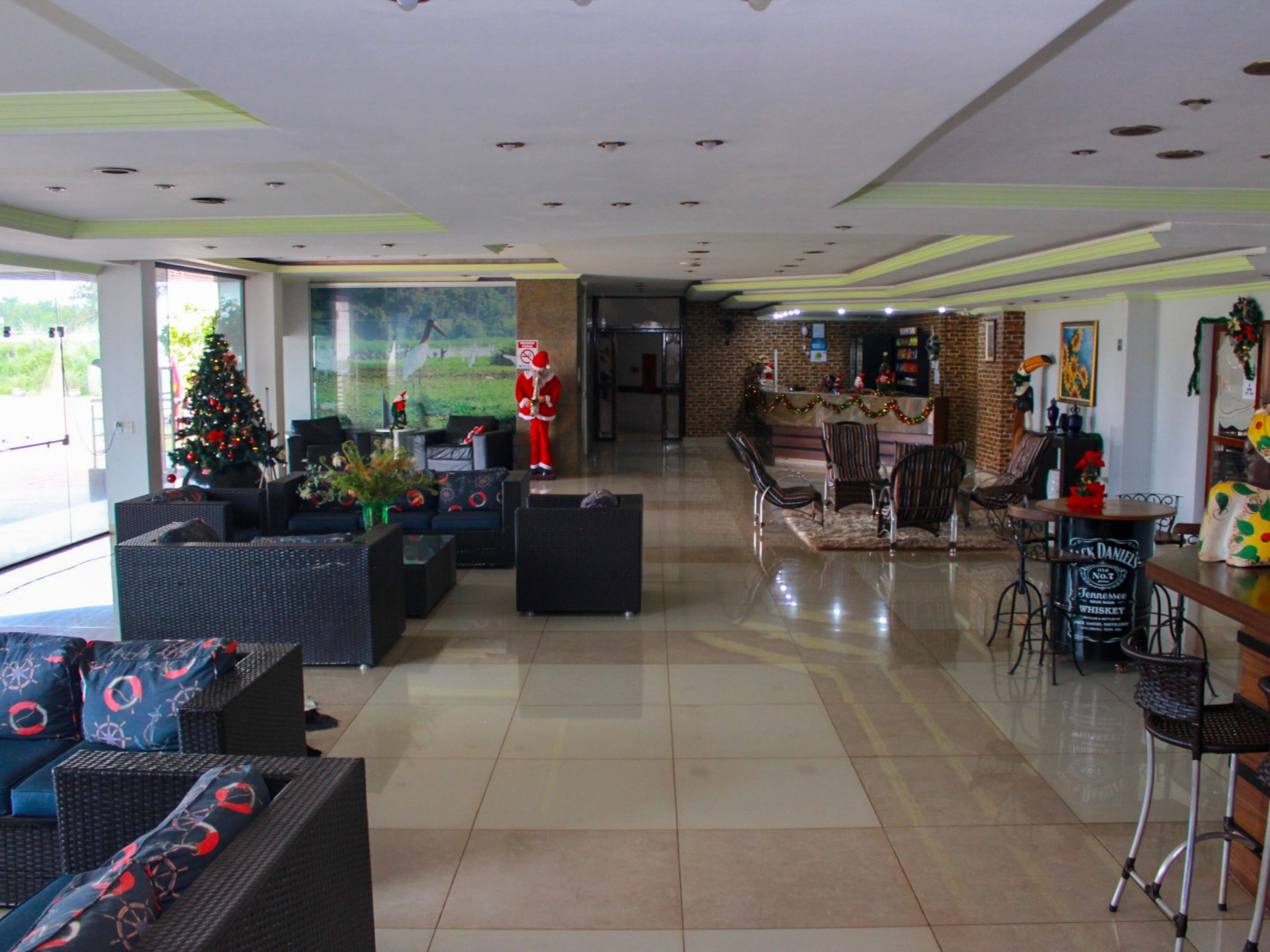 A spacious lobby with a Christmas tree, seating area, and a bar.