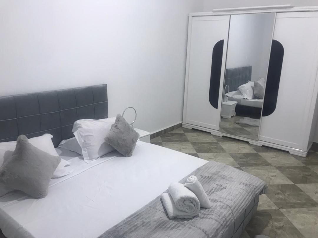 Habitació d'hotel amb llit, almoines, mirall i armari.