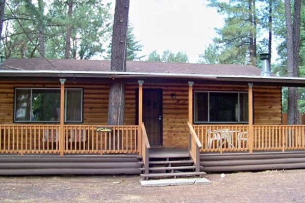 A log cabin with a porch, a front door, and a chimney. - Steps to the Lake! Pet Friendly! The Cedars Cabin (Lakeside)