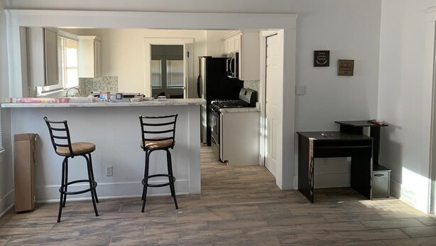 A modern kitchen with a central island, two bar stools, a refrigerator, and a small table. - 🏡⭐️Charming 2 bed. historical house -Centrl El Paso
 (El Paso)