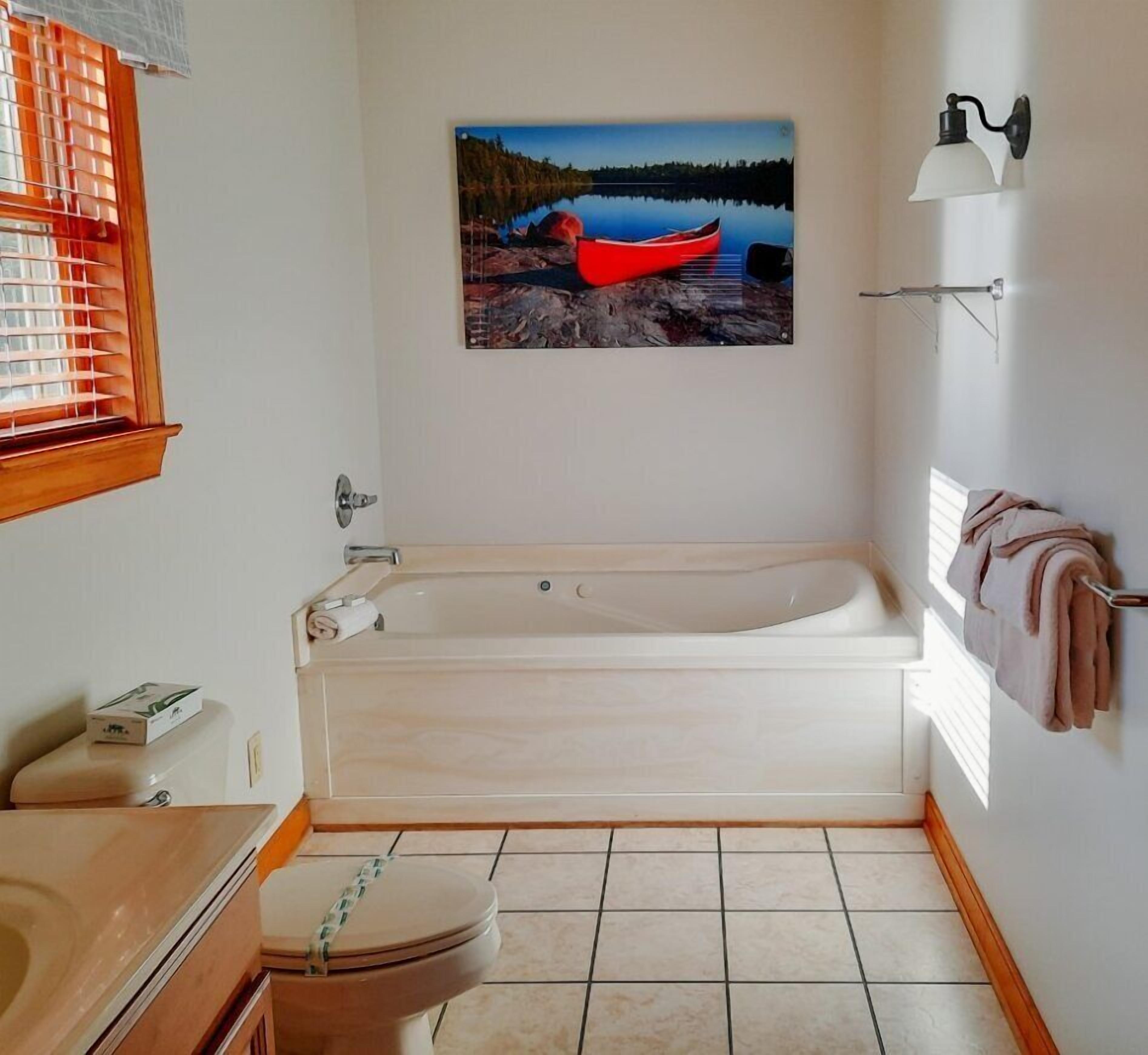 A bathroom with a bathtub, toilet, and sink.