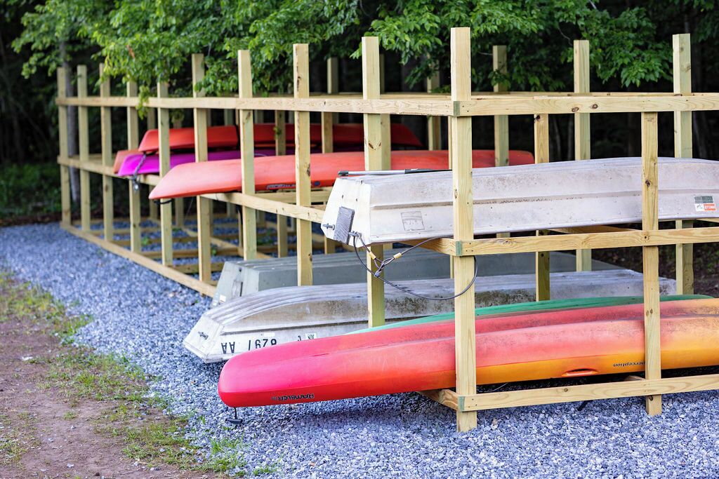 Una struttura in legno con kayak e una canoa.