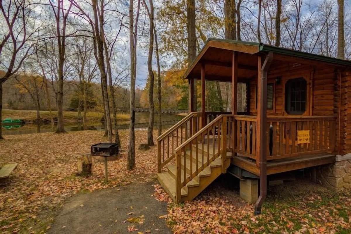 A wooden cabin with a porch and stairs leading to the entrance.