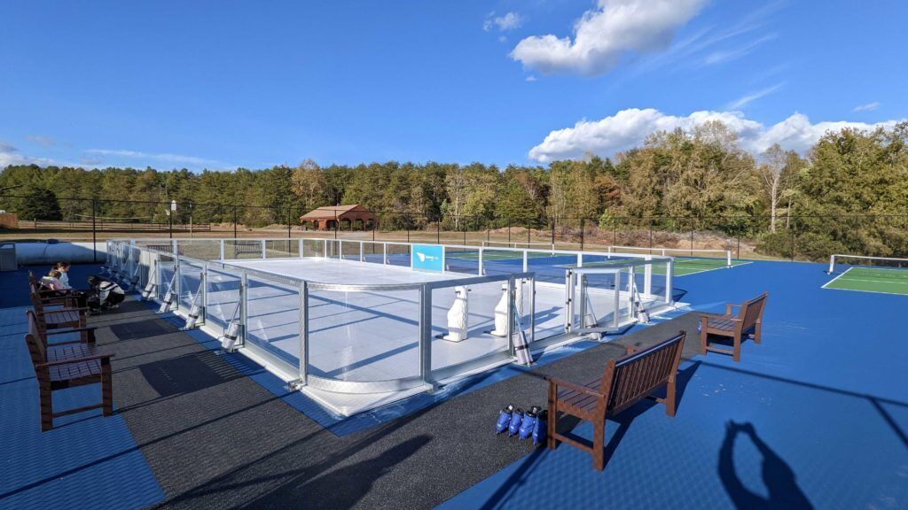 An outdoor pool area with a viewing platform, seating, and a covered section.