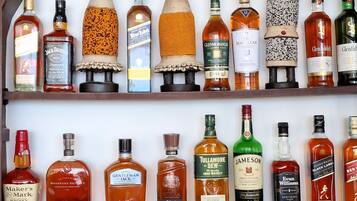 A bar with shelves of various liquor bottles and glasses.