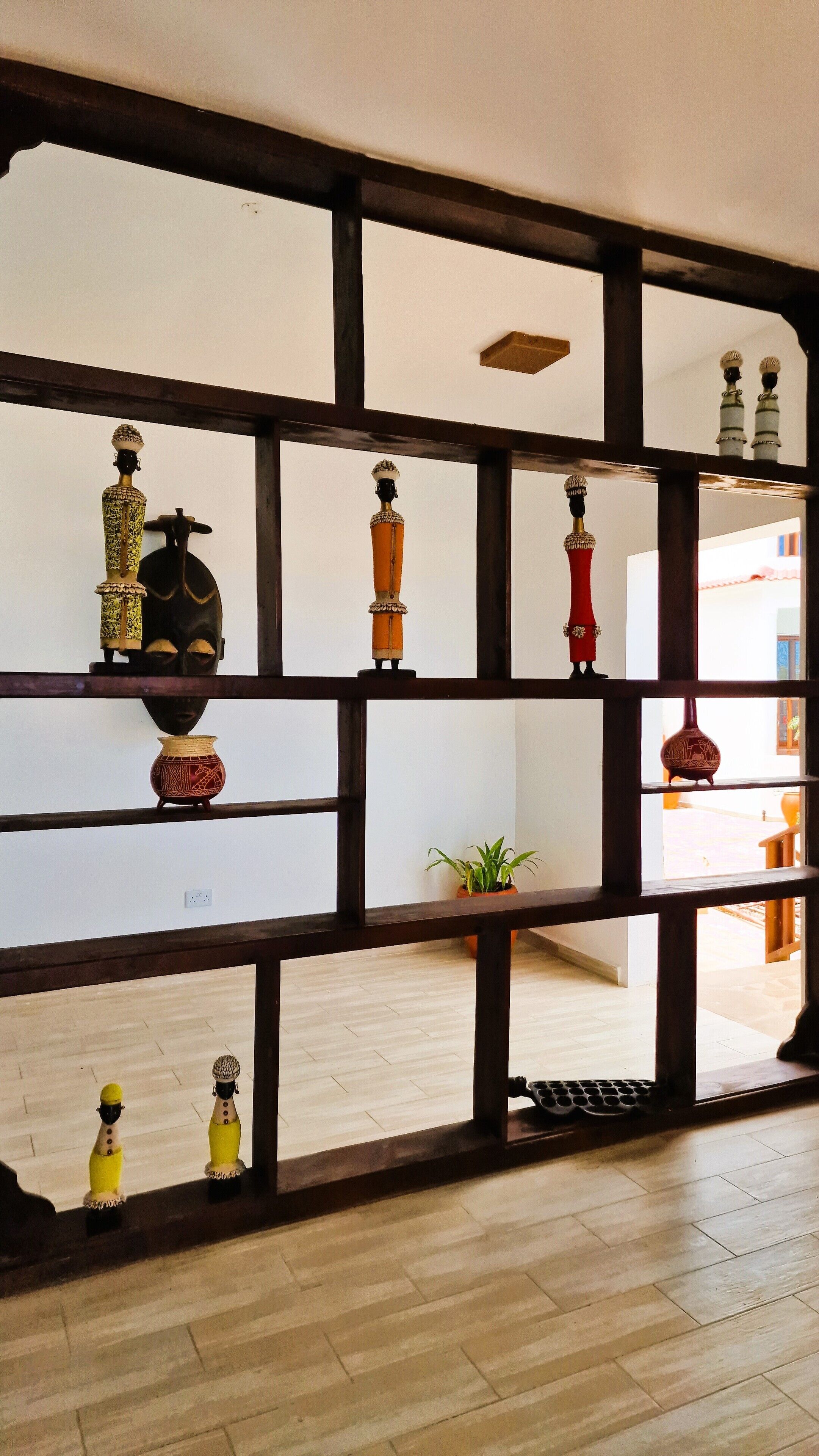 A room with a wooden bookshelf containing various decorative items.