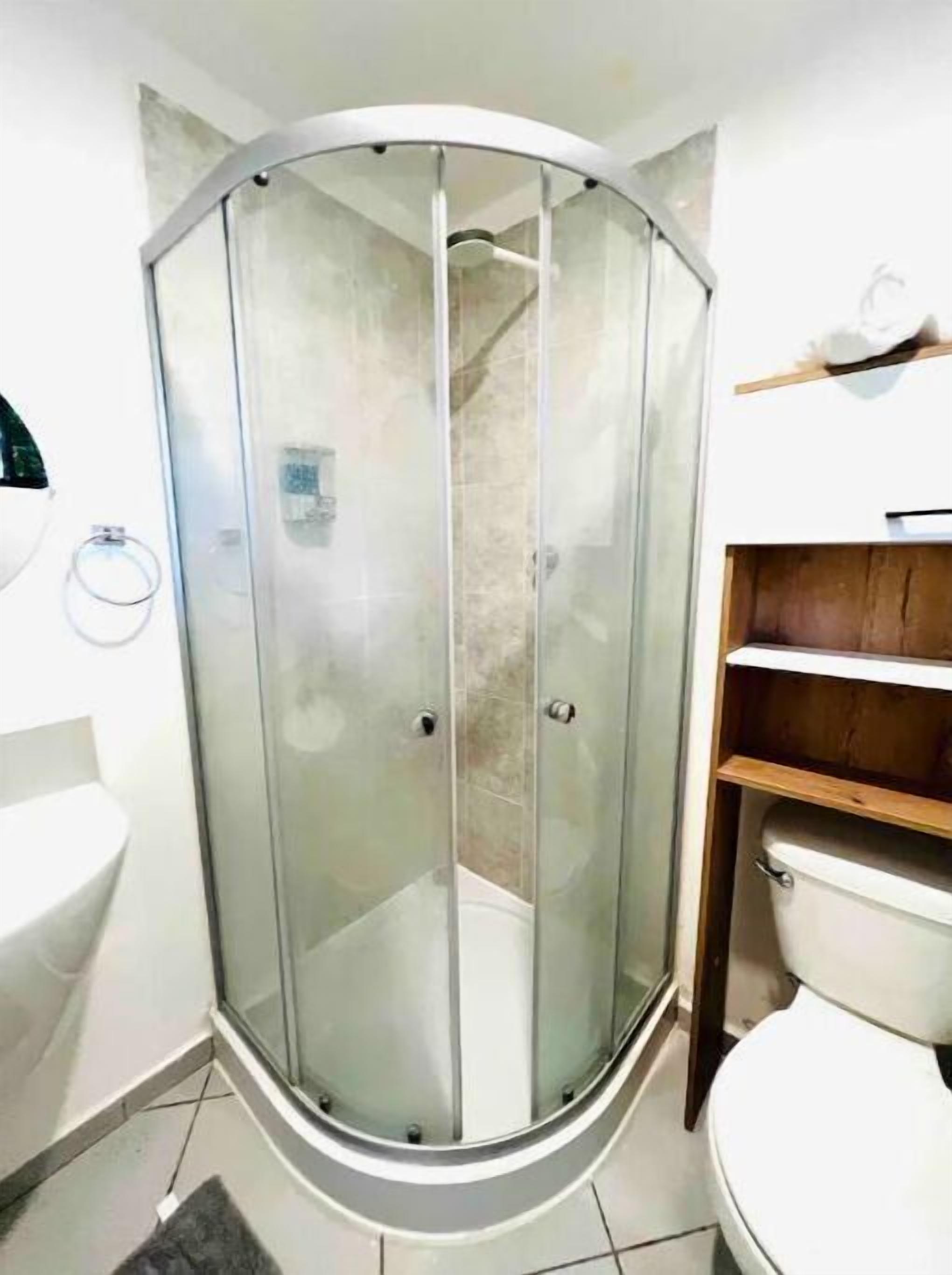 Ein Badezimmer mit Duschkabine, Waschbecken und Toilette.