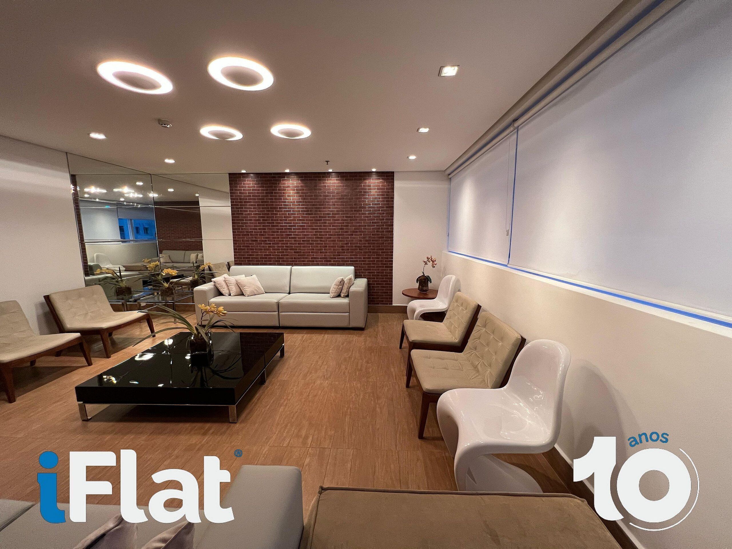 A modern waiting area with a sofa, chairs, a coffee table, and a wall-mounted TV.