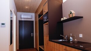 Una cocina moderna con armarios de madera, encimera negra y una pequeña repisa con adornos.