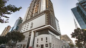 Un immeuble à étages doté d’une architecture moderne, caractérisé par une entrée imposante et une grande façade vitrée.