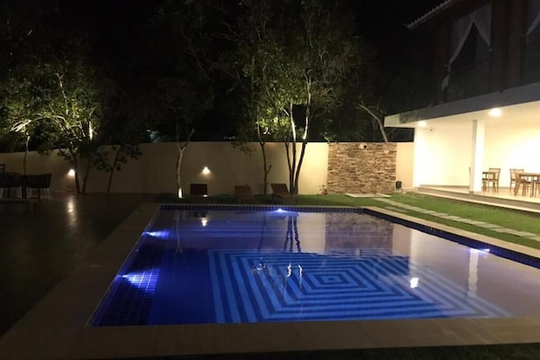 Una piscina al aire libre, sillones reclinables de piscina