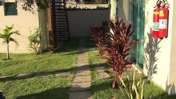 Un camino que lleva a un edificio con un extintor en la pared.