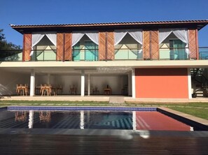 Una casa de dos pisos con piscina delantera.