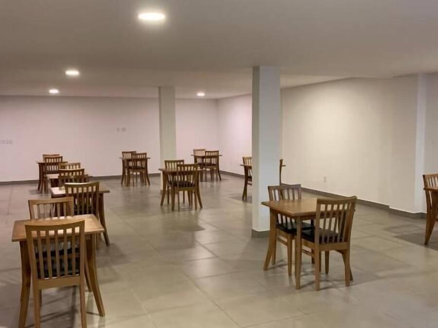 A spacious room with multiple wooden tables and chairs arranged for dining.