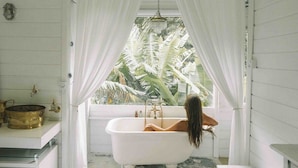 A bathroom with a bathtub, a shower, and a window with curtains. - Chalé Super Charmoso - CasaIvan (Florianópolis)