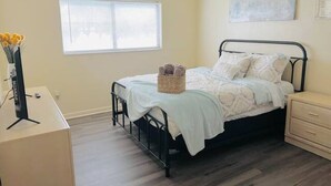 A bedroom with a bed, bedside table, and a window with blinds. - Beautiful 2 bedroom unit across from UF stadium
 (Gainesville)