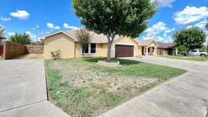A residential house with a front yard, a driveway, and a garage.